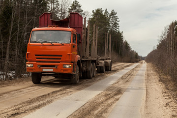 Orange empty Russian timber truck on a dirt road