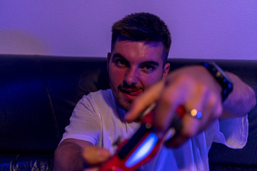 Chico joven jugando a la consola y comiendo palomitas