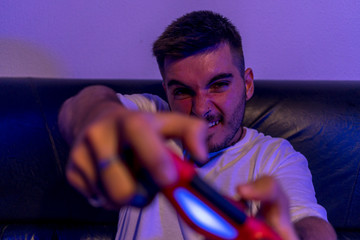 Chico joven jugando a la consola y comiendo palomitas