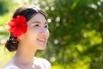夏の美容イメージ・ 赤いハイビスカスと黒髪の女性
