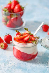 Jar of strawberry yogurt on color background