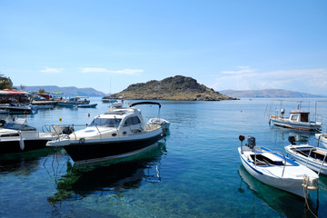 Obraz premium Boats are standing on amazing crystal clear water in marina. Island on horizon. Adriatic, Sveti Juraj, Croatia. 