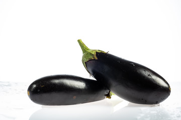 Eggplant on a white background with drops and splashes of water