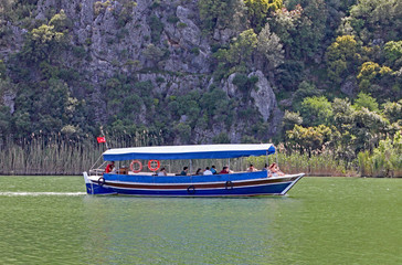 A vessels from the Dalyan Boat Cooperative passes by on the Dalyan River