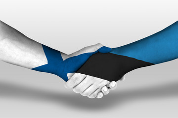 Handshake between estonia and finland flags painted on hands, illustration with clipping path.