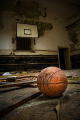 Dirty basketball in a destroyed court