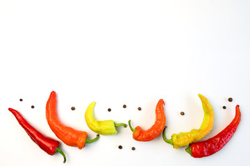 yellow, orange and red hot peppers on a white table. Concept of the harvest season, bright autumn.