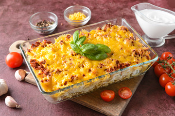 Baking dish with tasty beef casserole on color background