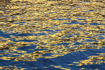 Wavy water texture background with reflected sunlight