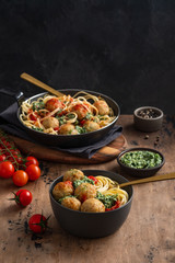 Pasta with meatballs and spinach with tomato sauce.