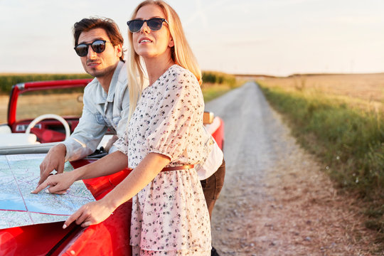 Couple with a map on the hood of the car