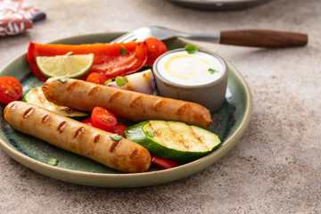 Grilled sausages with vegetables and sauce. Summer concept.