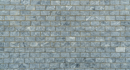 wall is lined with gray marble tiles.