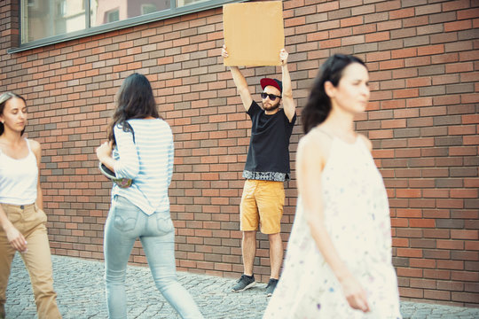 Dude with sign - man stands protesting things that annoy him. Solo demonstration his right to talk free on the street with sign. Copyspace for text. Opinion heard by public. Social life, humor, meme.