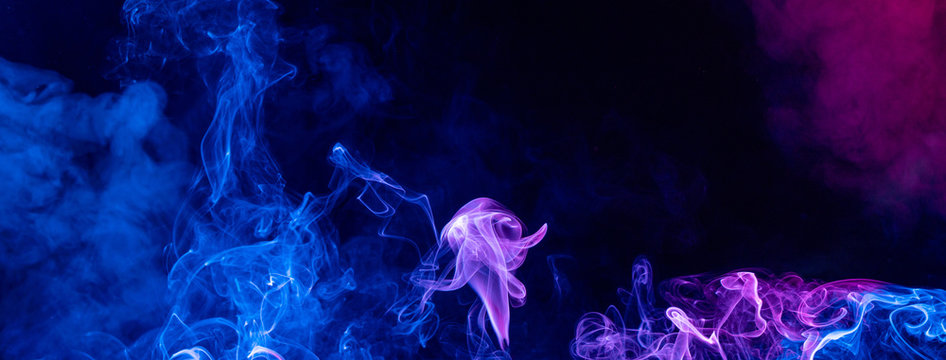 Conceptual image of multi-colored smoke isolated on dark black background, Halloween design element. - Powered by Adobe