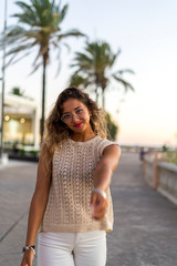 Chica joven y guapa junto a palmeras de compras