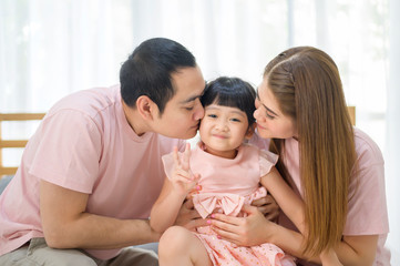 portrait of happy Asian family in white bedroom