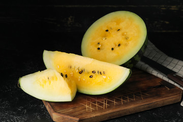 Cut yellow watermelon on dark background