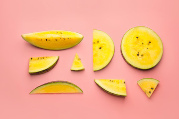 Cut yellow watermelon on color background