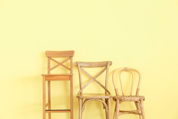 Fototapeta na wymiar Modern chairs near color wall