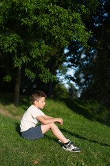 white guy sitting on  lawn in  green park, conceptual image of outdoor recreation