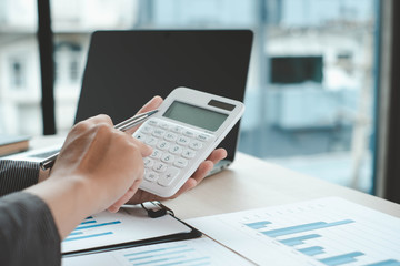 Business analysis, investment and finance concept. Business man, accountant calculate business report, marketing data, financial graph while working in office.