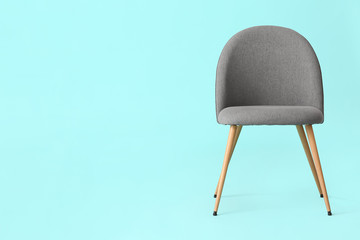 Modern chair on color background