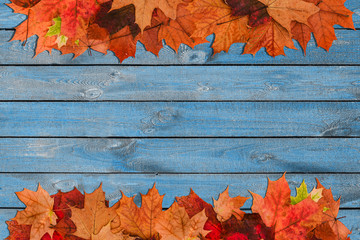 Obraz premium Autumn composition of leaves on a blue wooden surface. Autumn background with a copy of the space. The concept of autumn. Minimal style
