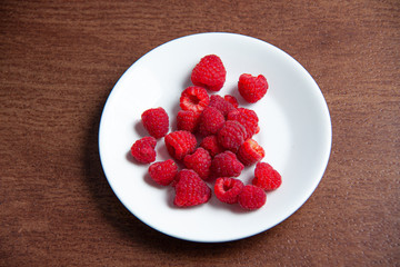 Fresh raspberries on a white plate 
