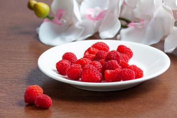 Fresh raspberries on a white plate 