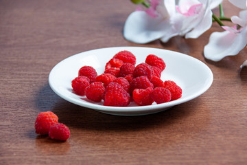 Fresh raspberries on a white plate 