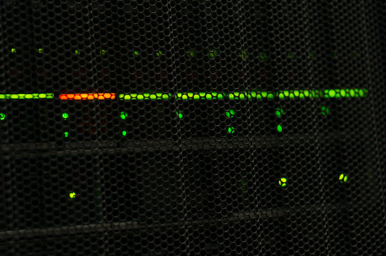 Photo of a server display in a telecommunications cabinet behind a perforated door.