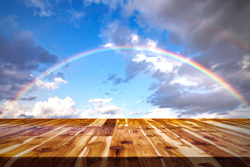 rainbow and clouds with brown wooden table top