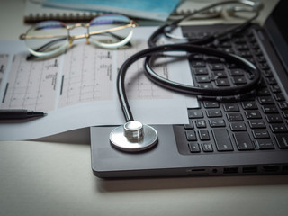 Stethoscope laptop medical protective mask.Doctor working desk.