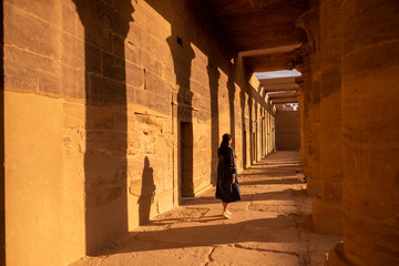 Women walking between large ancient pillars of Egypt, Appreciate the beauty of ancient things.