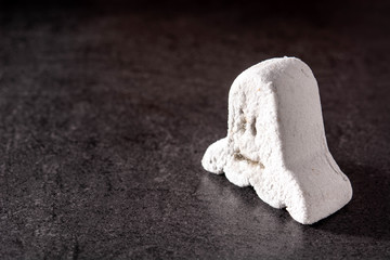 Halloween dessert with ghost shape on black background. Copy space