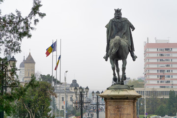 Fototapeta premium Stefan the Great statue with romanian flags fluttering in the background