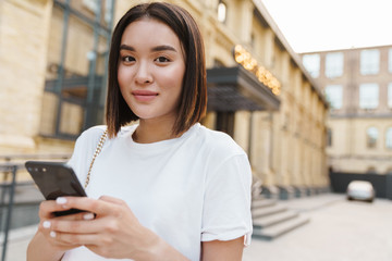 Asian woman outdoors using mobile phone