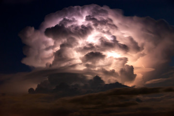 Dark cloud at  night with thunder bolt. Heavy storm bringing thunder, lightnings and rain in summer.
