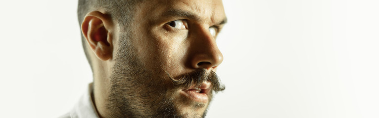 Fototapeta premium Asking. Caucasian young man's close up cropped shot on studio background, flyer. Concept of human emotions, facial expression, sales, ad. Copyspace. Beautiful male model with bright expression.