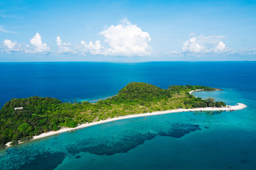 Fototapeta na wymiar Aerial scenery of picturesque island with crystal azure water and green vegetation.Bird's eye view of paradise beach shoreline, beautiful tourist destination for summer vacations, sport attractions