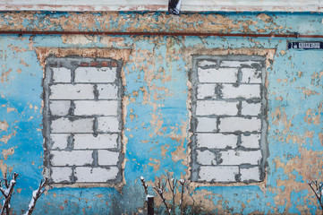Two walled-up windows in a blue house. High quality photo