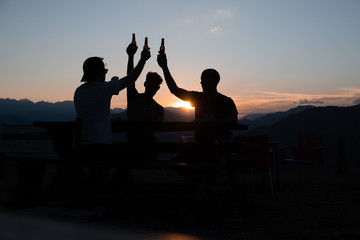 Fototapeta na wymiar Enjoying the sunset with friends in the mountains