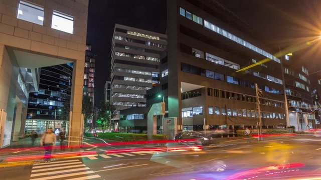 Night cityscape in business area with illuminated skyscrapers timelapse hyperlapse. San Isidro district Lima, Peru. Traffic on the street and glowing windows in offices