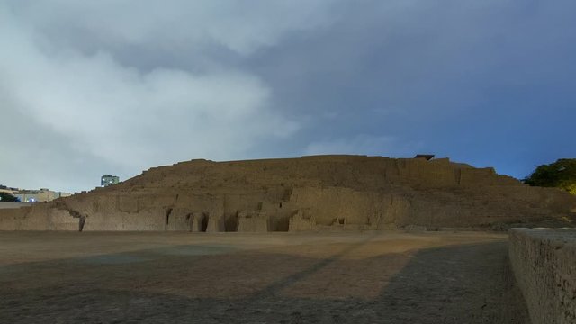 Pyramid of Huaca Pucllana day to night transition timelapse, pre Inca culture ceremonial building ruins in Lima, Peru. Clouds on a sky. Illumination is turning on