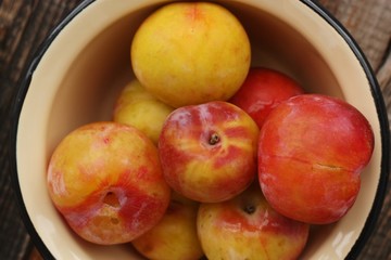 Juicy seasonal plums on the table macro