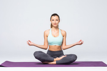 Fototapeta premium Portrait of young woman meditating in pose of lotus isolated on white background
