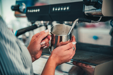 Fototapeta na wymiar bartender preparing hot milk on coffee machine