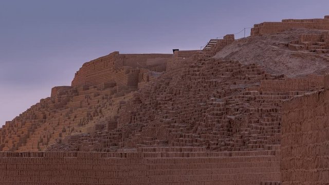 Pyramid of Huaca Pucllana day to night transition timelapse, pre Inca culture ceremonial building ruins in Lima, Peru. Clouds on a sky. Illumination is turning on
