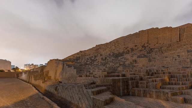 Pyramid of Huaca Pucllana day to night transition timelapse, pre Inca culture ceremonial building ruins in Lima, Peru. Clouds on a sky. Illumination is turning on